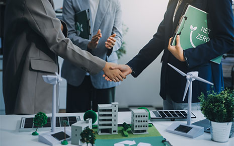 business men shaking hands over green business plans