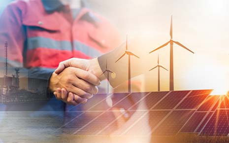 Two people shaking hands overlaid with wind turbines and solar panels